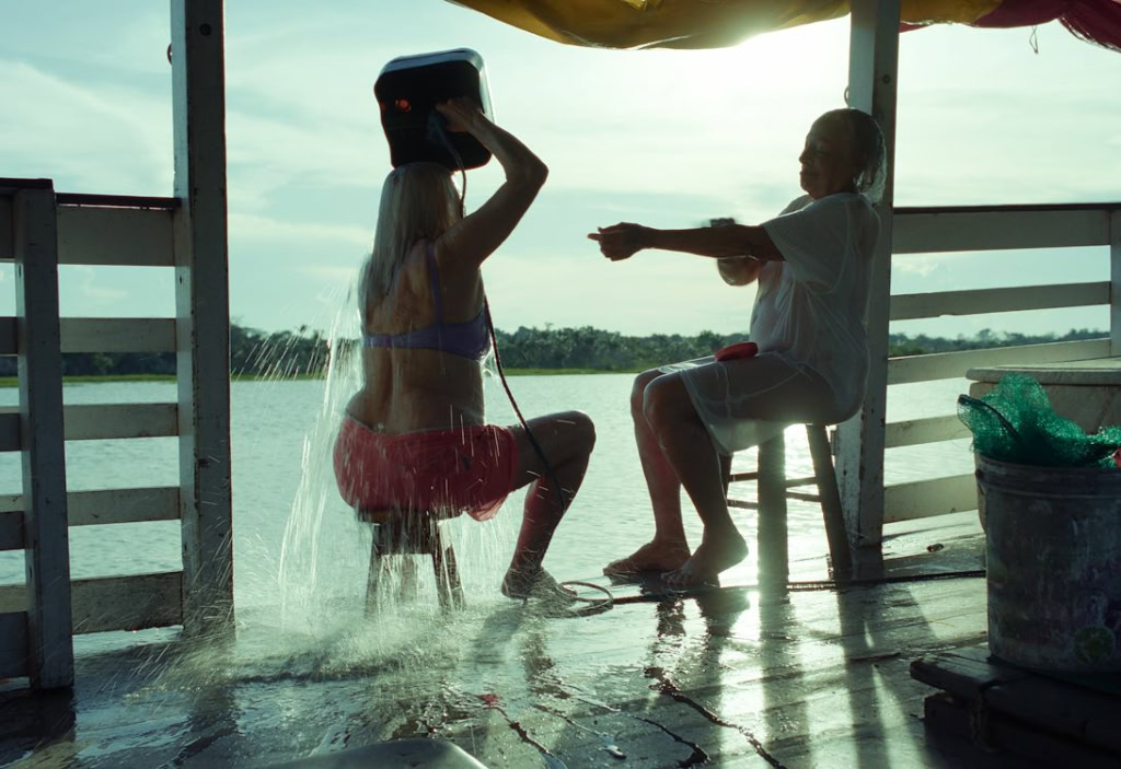 Vrouw in een roeiboot bij een waterkant, genieten van de natuurlijke omgeving met uitzicht op het meer, ontspannen activiteit, mogelijk tijdens een zomerse dag in Middelburg.