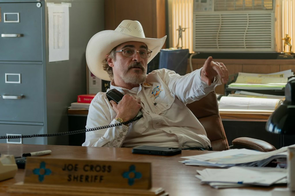Cowboy sheriff in an office talking on a landline phone, surrounded by files and documents, promotional movie scene at Cinema Middelburg.