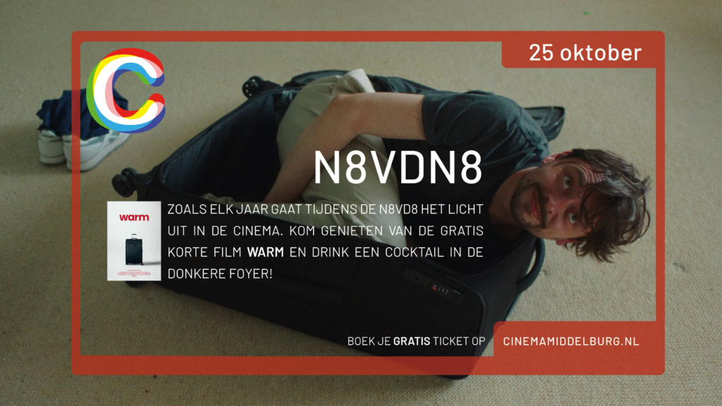 Vrolijk man ligt in koffer op vloer, promotie voor gratis film Warm bij Cinema Middelburg tijdens N8VD8 op 25 oktober.