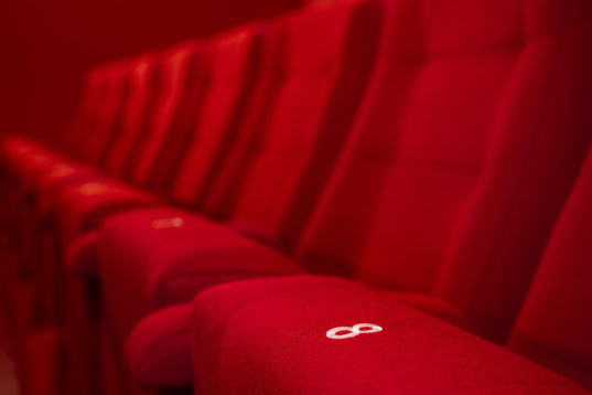 Geleid door SEO-zoekwoorden, toont deze afbeelding de luxe rode bioscoopstoelen bij Cinema Middelburg, uitnodigend voor een gezellige en comfortabele filmervaring in Nederland.