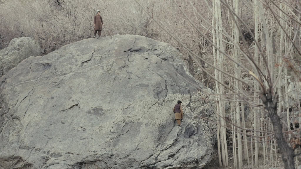 Twee mannen op een rots in een bos, symboliseert contemplatie en spiritualiteit in Kabul.