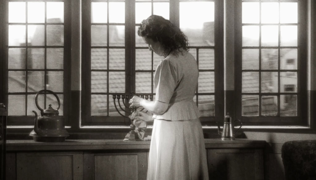 Een vrouw plaatst de chanoekia op de vensterbank tijdens Chanoeka.