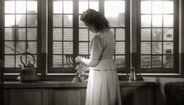 Een vrouw plaatst de chanoekia op de vensterbank tijdens Chanoeka.