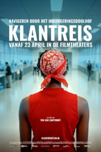 Klantreis film poster met een vrouw met rood bandana in een drukke luchthaven, promotie voor de film die vanaf 23 april in bioscopen te zien is.