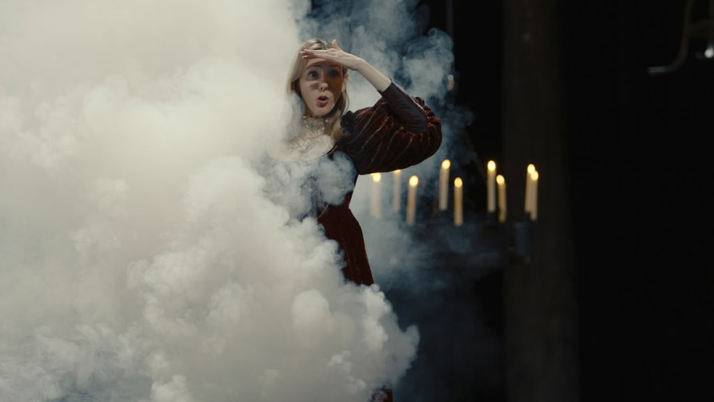 Actrice in een dramatische scène met rook en kaarsen, uit De la Comédie-Française, in een theater setting.