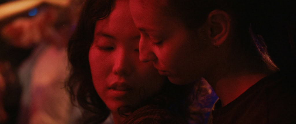 Close-up van twee vrouwen in een donkere, intieme setting, mogelijk uit de film La Petite Dernière, met een focus op emoties en sfeer.