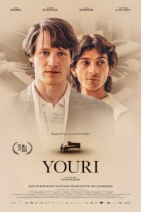 Filmstill van twee jonge mannen, mogelijk hoofdpersonen, in een filmthema, met een piano op de achtergrond, promotie voor de film Youri.