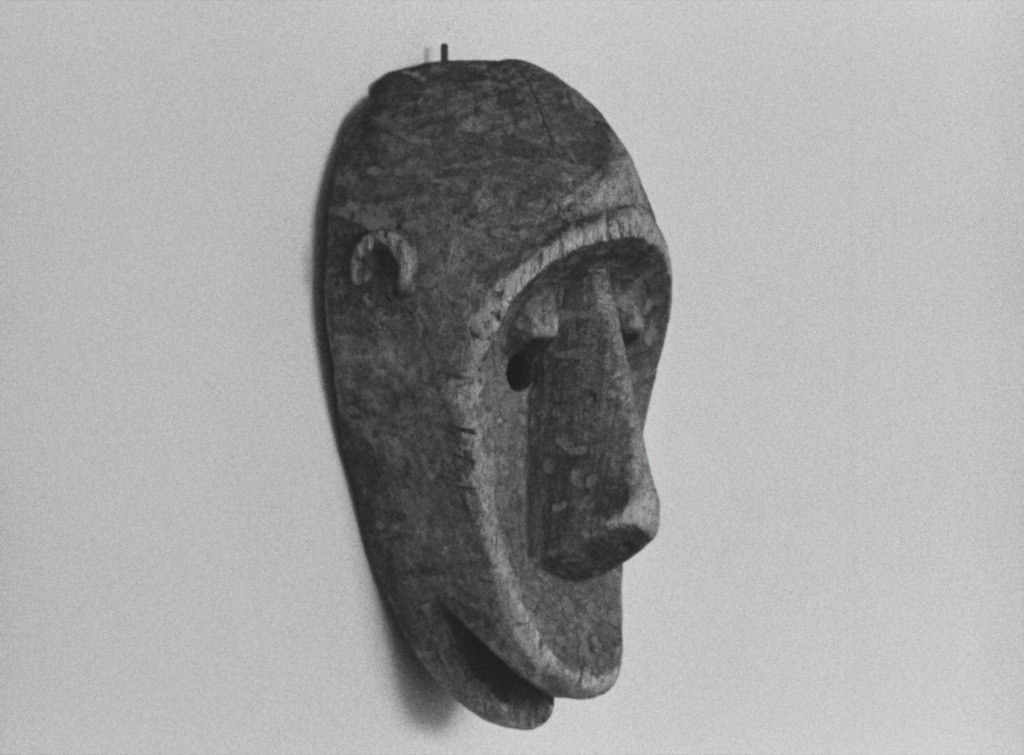 Afrikaanse houten masker met gedetailleerde gezichtskenmerken, getoond op een neutrale achtergrond, geschikt voor film- en cultuurthema's.