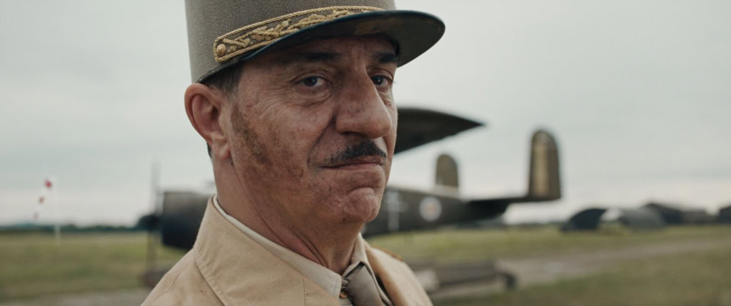 Close-up van een man in militaire uniform met een vliegtuig op de achtergrond, symboliseert historische oorlogsthema's en heldenverhalen.