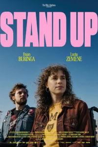Stand Up poster met twee acteurs voor publiek, heldere blauwe hemel en grote roze titel.