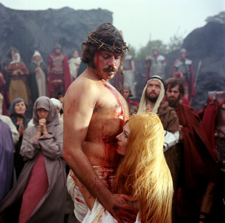 Scène uit de film 'De Duivels' met een kruisiging-achtige scène, middeleeuwse setting, dramatisch en intens.